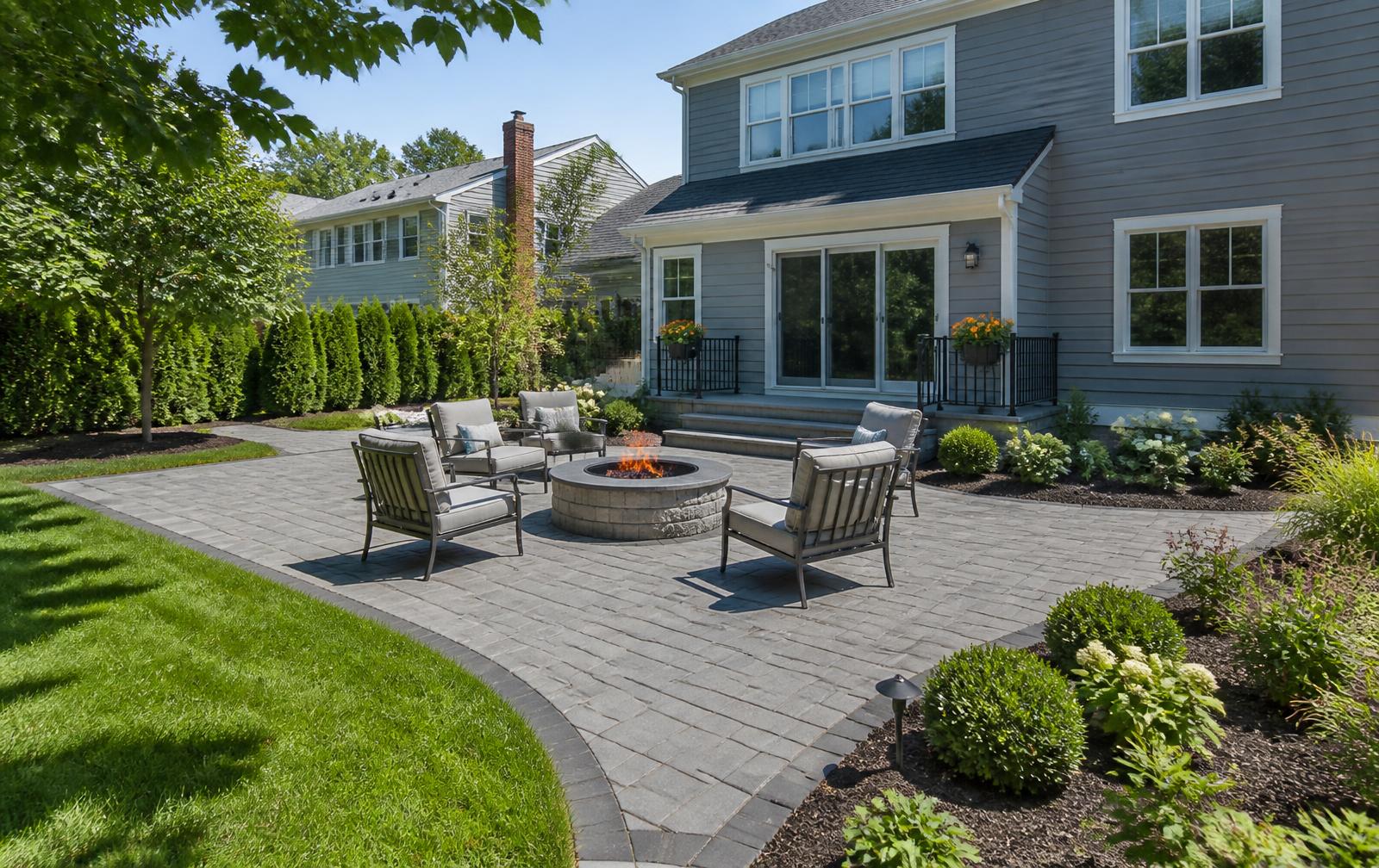 Paver patio with fire pit and seating area off the back of a home